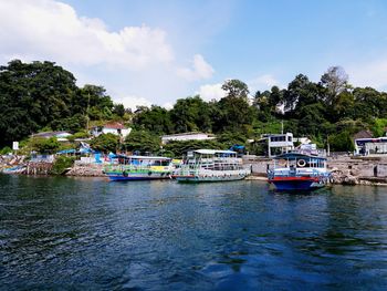 Boats moored on river against sky