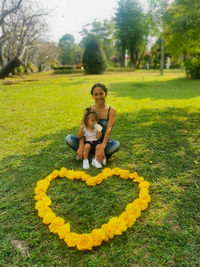 Full length of father and daughter on grassy field