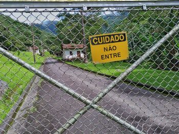 Close-up of warning sign on chainlink fence