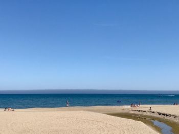 Scenic view of beach against clear blue sky