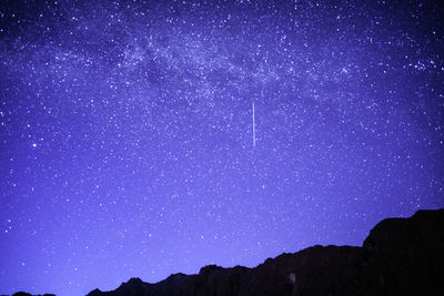 Low angle view of stars on mountain against star field