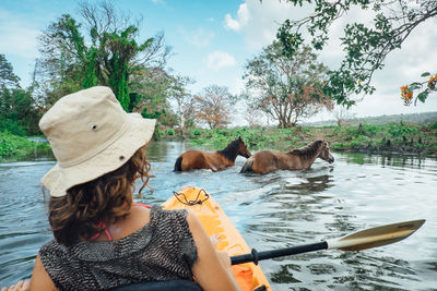 Rear view of woman kayaking in river