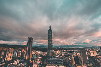 Skyscrapers in city against cloudy sky