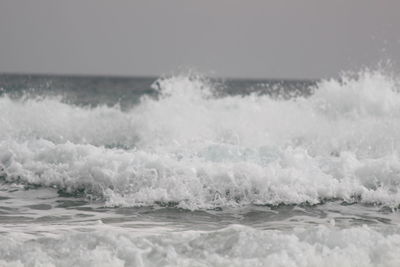 Close-up of waves in sea against sky