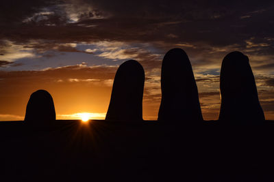 Silhouette of building against cloudy sky during sunset