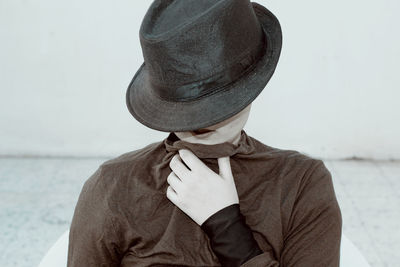 Close-up of man wearing hat standing against sea