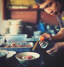 Close-up of man preparing food in bowl