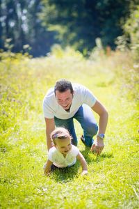 Man playing with daughter on grass