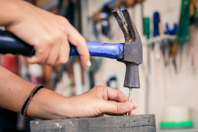 Close-up of person working on metal