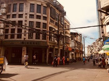 People walking on road along buildings