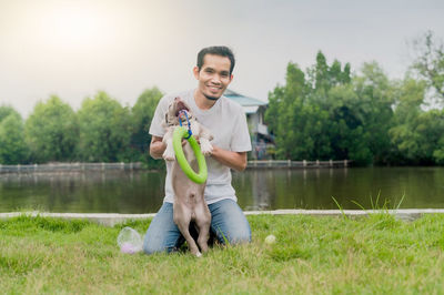 Portrait of a smiling young man standing on lake