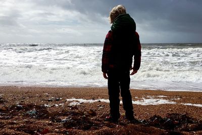 Rear view of people standing on beach