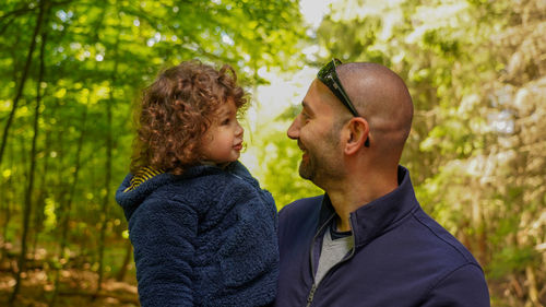 Side view of father and daughter in forest