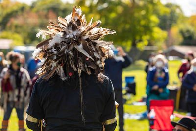 Rear view of woman wearing mask standing outdoors