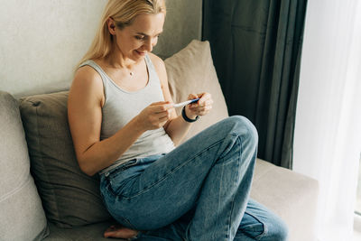 A middle-aged woman checks a pregnancy test.