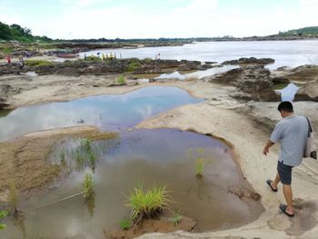 Rear view of man standing on beach