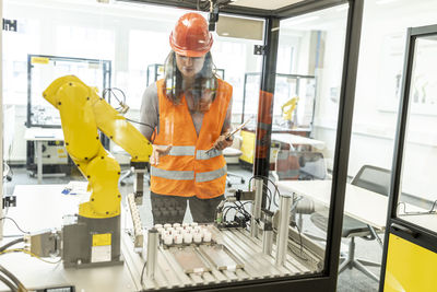 Female skilled worker training robotic arm