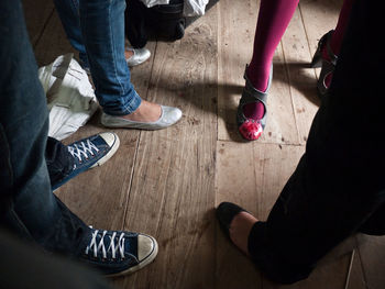 Low section of people standing on hardwood floor