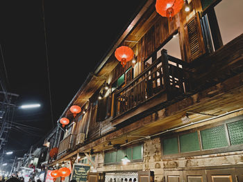 Low angle view of illuminated lanterns hanging on building at night