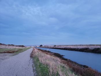 Road amidst land against sky