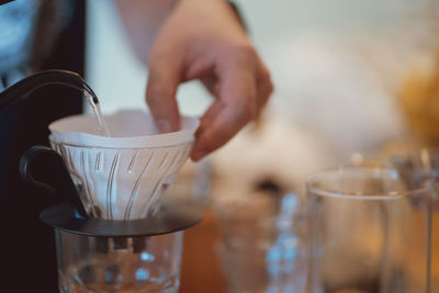 Close-up of hand pouring tea in glass