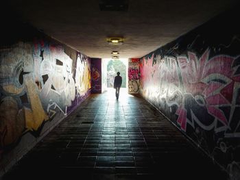 Rear view of man walking in subway tunnel