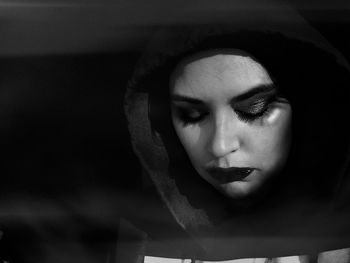 Close-up of stressed woman against black background