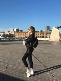 Full length of woman standing on city against clear sky