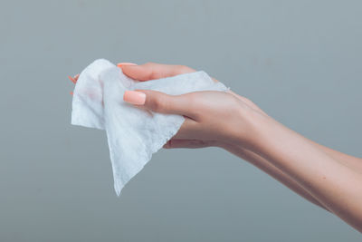 Close-up of hand holding paper over white background