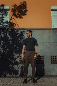 Portrait of young man standing against tree