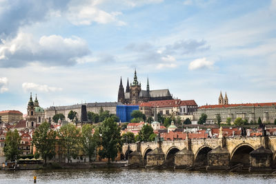 Arch bridge over river against buildings in city