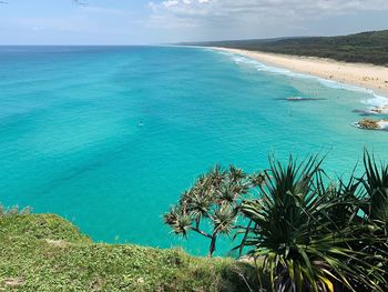 Scenic view of turquoise sea with lone paddle boarder 