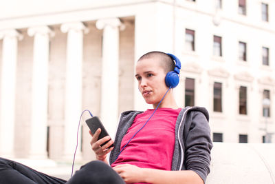 Young man using mobile phone in city