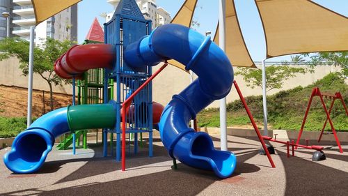 Rear view of child on slide at playground