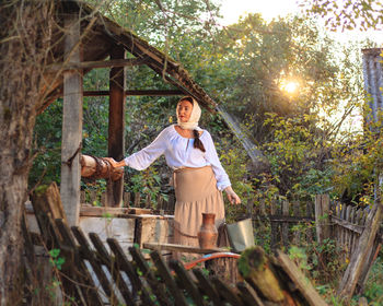 A village young peasant woman is engaged in work in the morning early carries water from the well