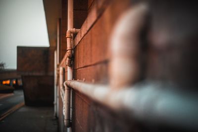 Close-up of metal railing against wall in city