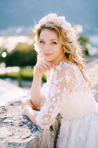 Portrait of smiling young woman standing against sky