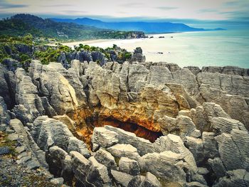 Scenic view of rock formations in sea against sky