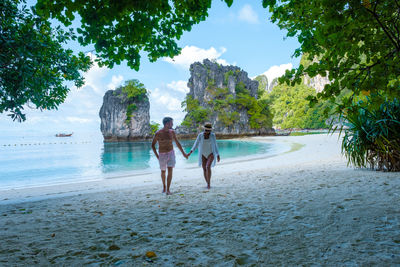 Rear view of woman walking at beach