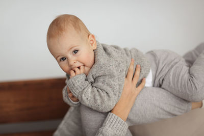 Portrait of cute baby boy lying on bed at home