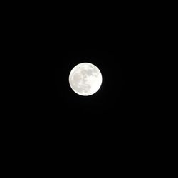 Low angle view of full moon against black sky