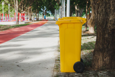 Garbage can on footpath at park