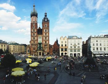 People at town square with st mary church against sky