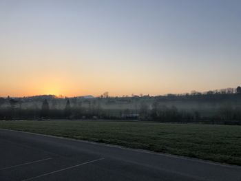 Scenic view of field against clear sky during sunset