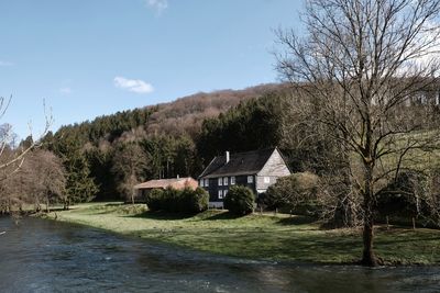 House amidst trees and buildings against sky