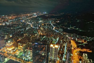 Aerial view of illuminated cityscape against sky at night