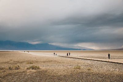 People at beach against sky