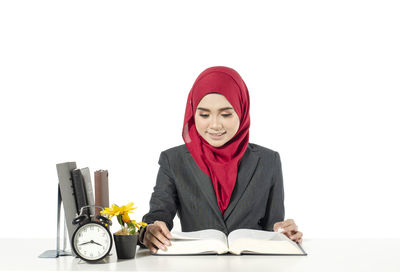 Portrait of a smiling young woman against white background