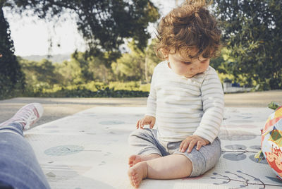 Full length of boy sitting on paper outdoors