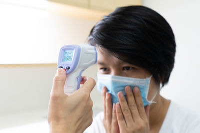 Close-up of doctor examining patient temperature